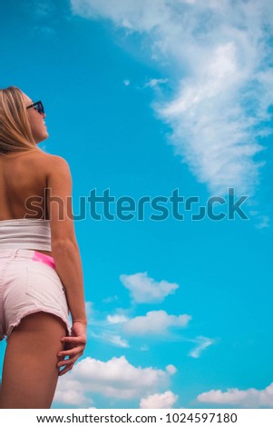 Young girl in shorts against the sky