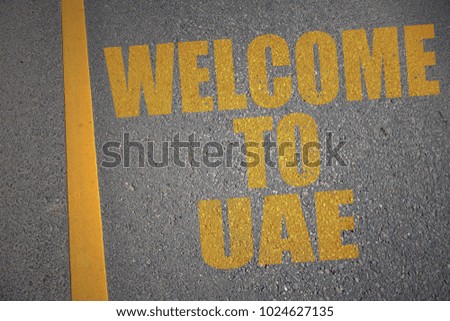 asphalt road with text welcome to uae near yellow line. concept