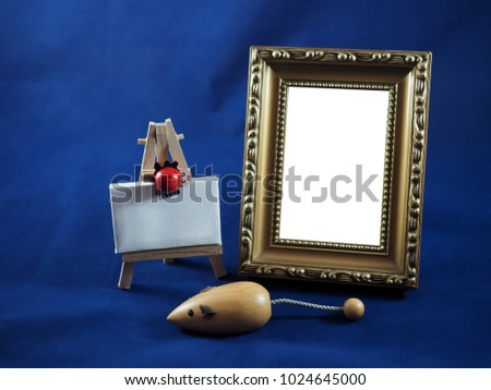 
Vintage golden frame in which to insert a photo, a painter's canvas on which to leave a message. Wooden mouse and lucky ladybug. Blue background.
