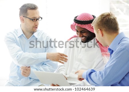 Multicultural different ethnic group working on laptop together