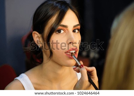 Photo of model girl and stylist with brush