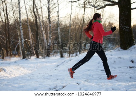 Image of sports woman on run through winter forest