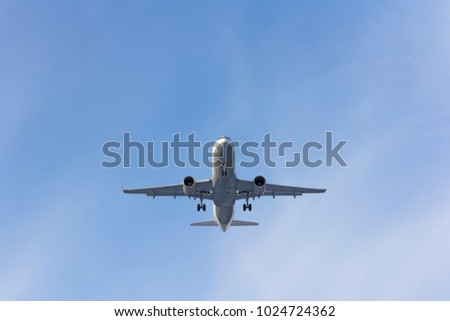 Airplane flies against a background of white clouds