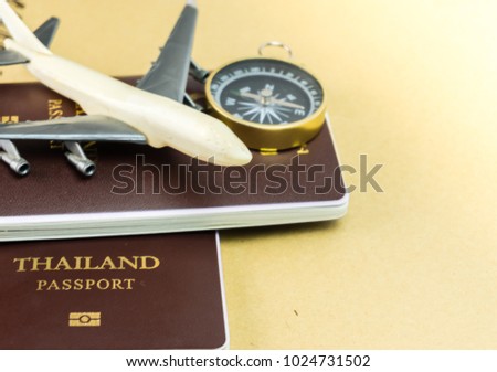 passports on the floor, decorated with a compass, a white model airplane. Concepts about travel or transportation by air