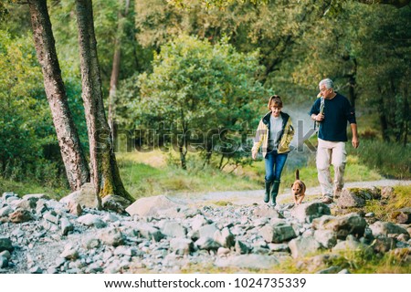 Senior couple are hiking through the Lake District together with their pet dog. Royalty-Free Stock Photo #1024735339