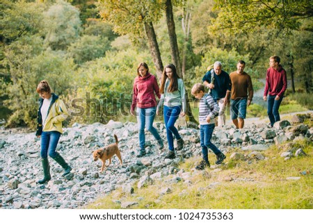Three generation family are hiking together through the Lake District with their pet dog. Royalty-Free Stock Photo #1024735363