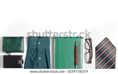 Men's accessories. Tie, green notebook, glasses, purse, business card holder. White background. Flat top view. Space for text

