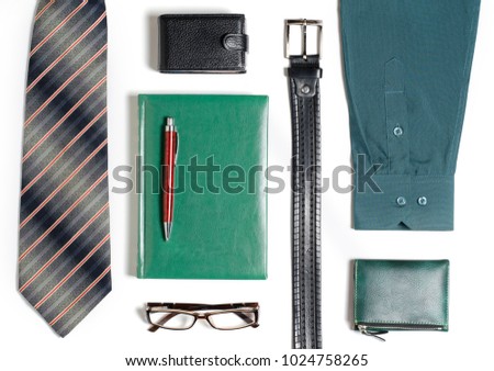 Men's accessories. Tie, green notebook, glasses, purse, business card holder. White background. Flat top view
