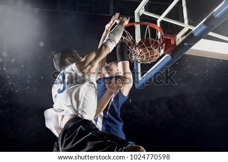 Two basketball players in action in gym Royalty-Free Stock Photo #1024770598