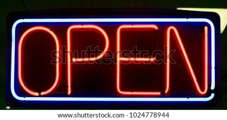A red open neon sign shows with a blue square around it.