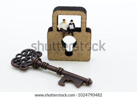 Miniature people: Businessmen sitting on the master key and reading newspaper. Image use for key man, the key to success, business concept.