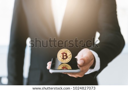 business man holding smartphone with bit coin on screen ,business technology network concept 
