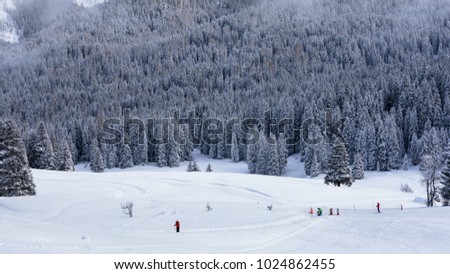 People skiing into snowy landscape in the mountains