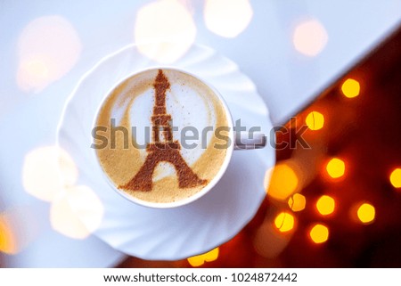 coffee cappuccino in a white cup in a cape in paris with a drawing of a tower of cinnamon