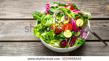 Fresh salad on a wooden background top view, concept of healthy food and veggie