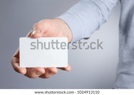 Male hand holding a white card on white background
