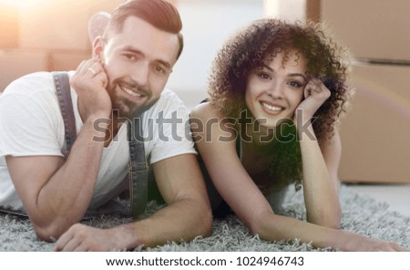Portrait of a married couple lying on the floor after moving