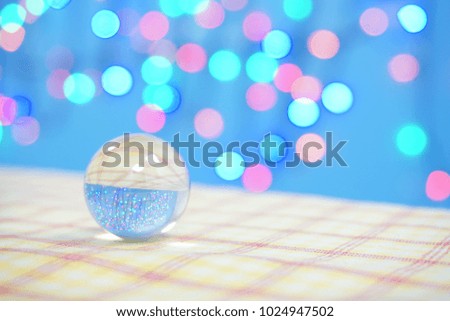 Single glass bead on table and light bokeh background