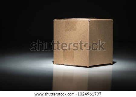 Blank Carboard Shipping Box Under Spot Light. Royalty-Free Stock Photo #1024961797