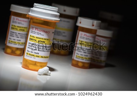 Hydrocodone Pills and Prescription Bottles with Non Proprietary Label. No model release required - contains ficticious information. Royalty-Free Stock Photo #1024962430