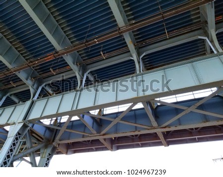 Close up from underneath of the Benjamin Franklin railway Bridge in Philadelphia showing the lattice work and structural steel supports
