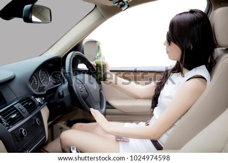 Picture of beautiful woman holding a beer bottle while driving a car, isolated on white background