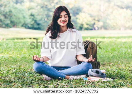 Woman practicing yoga on green grass background
