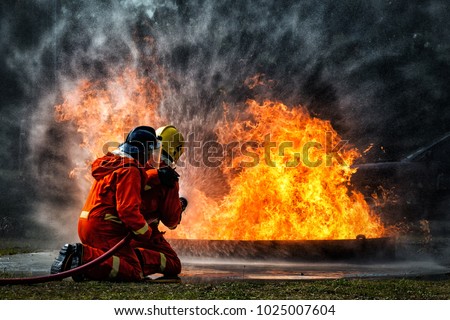 firefighter training., fireman using water and extinguisher to fighting with fire flame in an emergency situation., under danger situation all firemen wearing fire fighter suit for safety. Royalty-Free Stock Photo #1025007604
