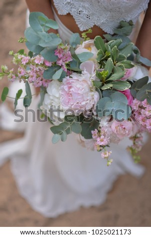 Bride holding her boho wedding bouquet. Perfect image for wedding style magazines and websites, copyspace, fashion, bohemian, flowers decoration businesses, florist and other related subjects.