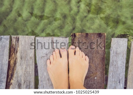 Legs on the old pier on the background of the sea. Royalty-Free Stock Photo #1025025439