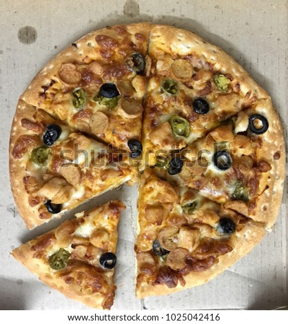 Pizza with chicken sausage, grilled chicken, olives and jalapenos in white background