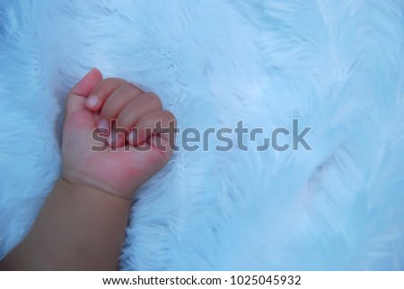 close up the baby's left hand picture on a white blanket