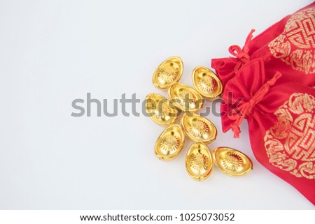 Chinese New Year traditional concept the red bags ,golden ingots on white background ,the Chinese character on bags and ingots are represented the symbol of happiness and good fortune, Good luck.