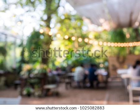 Blurred background of outdoor restaurant with abstract bokeh light.