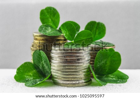 Stacks of Russian coins with clover leaves on a gray background with droplets of water. St.Patrick 's Day
