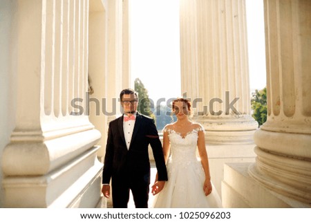 wedding couple posing in sun near old structure