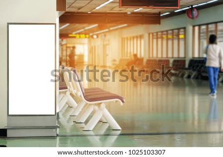 mock up of vertical blank advertising billboard or light box showcase with people walking at airport, copy space for your text message or media content, advertisement, commercial and marketing concept