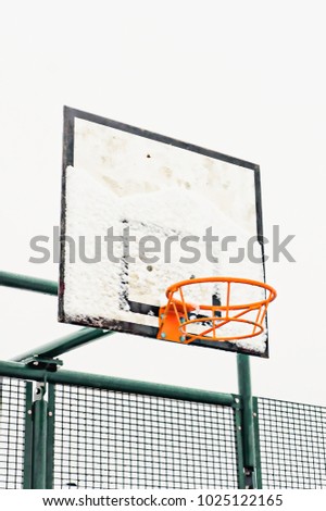 A basketball ring and board with thawing snow