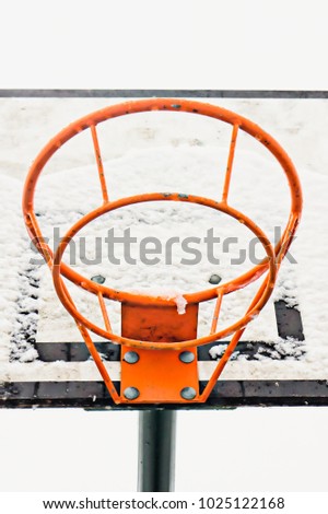A basketball ring and board with thawing snow
