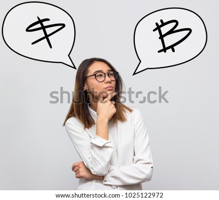 Young beautiful woman thinking about investitisions, choosing between dollar and cryptocurrency bitcoin. Business concept. Selective focus and shallow DOF