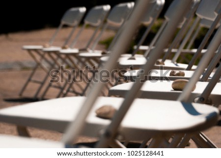 Rocks lining chairs at an outdoor wedding. 