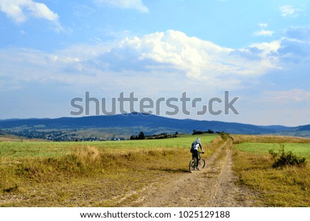 Male mountain biker is traveling on dirt road at afternoon