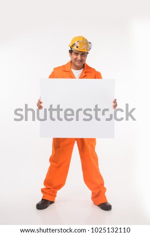 Happy Indian Male electrician or industrial Worker With Blank Placard or board Over White Background