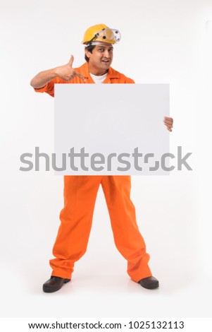 Happy Indian Male electrician or industrial Worker With Blank Placard or board Over White Background