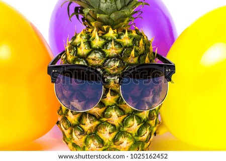 close-up image pineapple in glasses among colorful balloons, isolated on white background, concept of birthday