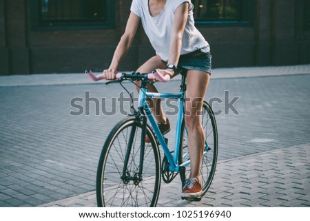 Young beautiful girl rides her single speed of fixed gear bicycle in the city. Toned picture