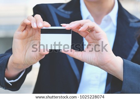 Businesswoman in black costume show business card or name card, woman holding credit card in hand, female is introduced by giving blank card