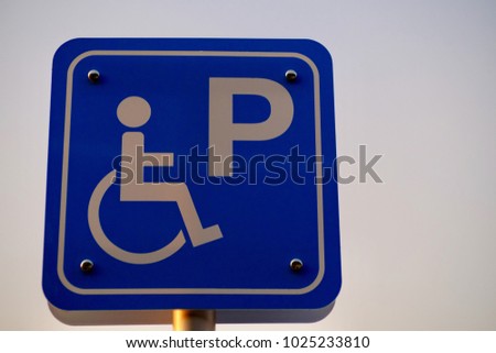Symbolic of Disabled Parking Badge with sky background.Over exposed