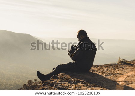 Nature photographer taking a photo of mountain view during sunrise 