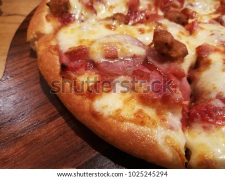 hot pizza slice with dripping cheese on wooden board table